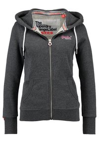 Haut de survêtement gris zippé avec capuche à cordon, poches avant et poignets côtelés. Présente des accents de logo à l'intérieur du col et sur la poitrine.