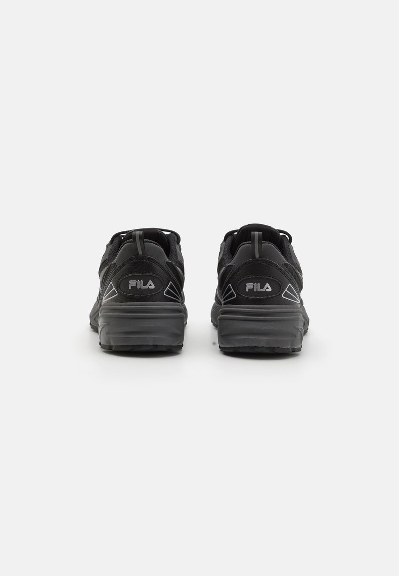Zwarte sportieve schoenen met een gestructureerde bovenkant, voorzien van een trekhaak en het Fila-logo op de hak, en een dikke rubberen zool met tractie-details.