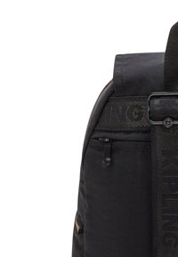 Zaino nero realizzato in materiale nylon resistente, con tracolla regolabile con logo, tasca laterale con zip e texture in tessuto con dettagli di cucitura.