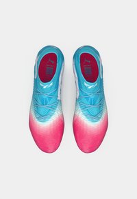 Une paire de chaussures de sport dégradées bleu et rose avec des lacets, vues de dessus, sur fond blanc.