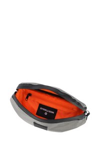 Sacca esterna grigia con una texture liscia e dettagli neri; interno arancione brillante con una piccola tasca con zip e etichetta di marca.