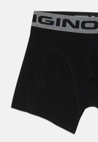 Boxer in cotone neri con un elastico grigio in vita che presenta il nome del marchio in bold nero e dettagli di cuciture piatte.
