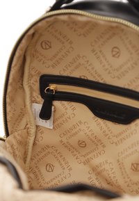 Interno in pelle nera di una borsa con rivestimento beige chiaro caratterizzato da un motivo a ripetizione del logo "CAFÉ NOIR" e una tasca aggiuntiva con zip.