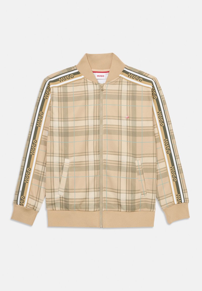 Jaqueta bege em padrão xadrez com fecho zip e gola e punhos canelados. Apresenta a marca HUGO em riscas verdes e amarelas nas mangas. Dois bolsos laterais.