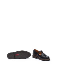 Zwarte leren schoenen met een platte hak, voorzien van een band over de wreef, decoratieve uitsparingen en een gestructureerde rubberen zool met rode accenten.