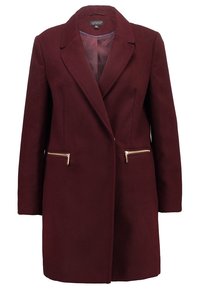 Burgundyröd ullblandningsjacka med slagkrage, långa ärmar och två dragkedjefickor fram med guldaccenter. Slät innerfoder.