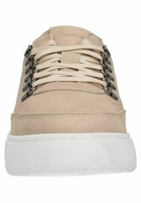 Sneaker in suede beige con suola in gomma bianca testurizzata, dotata di anelli metallici per i lacci e lacci piatti, design minimalista.