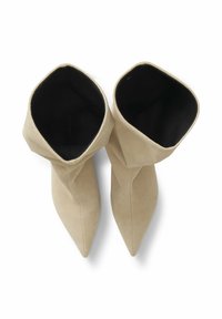Beige suède enkellaarsjes met een spitse neus en een gevouwen kraag, met een zwarte binnenvoering. Soepele textuur met minimale details.