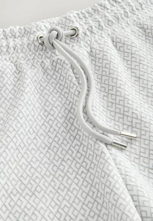 Light gray shorts with a geometric pattern, featuring an elastic waistband, silver hardware, and a drawstring for adjustment.