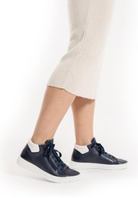 Navy leather high-top sneakers with white accents, featuring a textured finish, laces, and a side zip for easy wear.