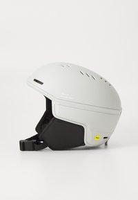 Biela lyžiarska prilba s ventilačnými otvormi, čiernymi ušnými vypchávkami a výrazným logom "Sweet Protection". Obsahuje žltú nálepku MIPS pre bezpečnosť.