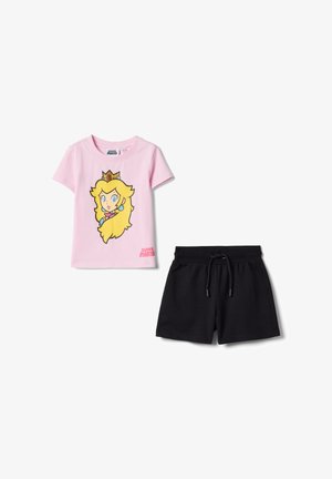 T-shirt rose à manches courtes avec un motif de la Princesse Peach et le texte "Super Mario", accompagné d'un short noir à taille élastique avec cordon de serrage.