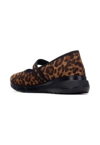 Zapatos con estampado de leopardo y textura de ante suave, detalles en negro y suela de cuña. Presentan una correa elástica a lo largo del tobillo.