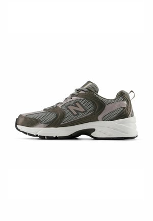 Grijze en olijfgroene New Balance sportschoen met meshstof, vetersluiting en witte dempende zool, zijaanzicht.