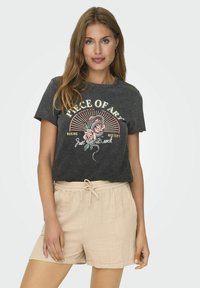 Zwarte katoenen t-shirt met grafische print van rozen en tekst. Gecombineerd met beige textuur shorts met een elastische tailleband.