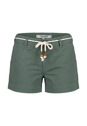 Groene damesshorts met opgerolde zoom en een witte gevlochten riem met houten kraalaccenten, voorgebonden in een strik.