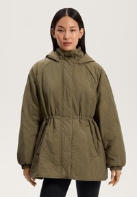 Oliivivärvi quiltitud jakk, kapuutsiga, coretud talje, elastsete äärte ja küljetaskutega; kangas on kaunistatud teemantmustriga.