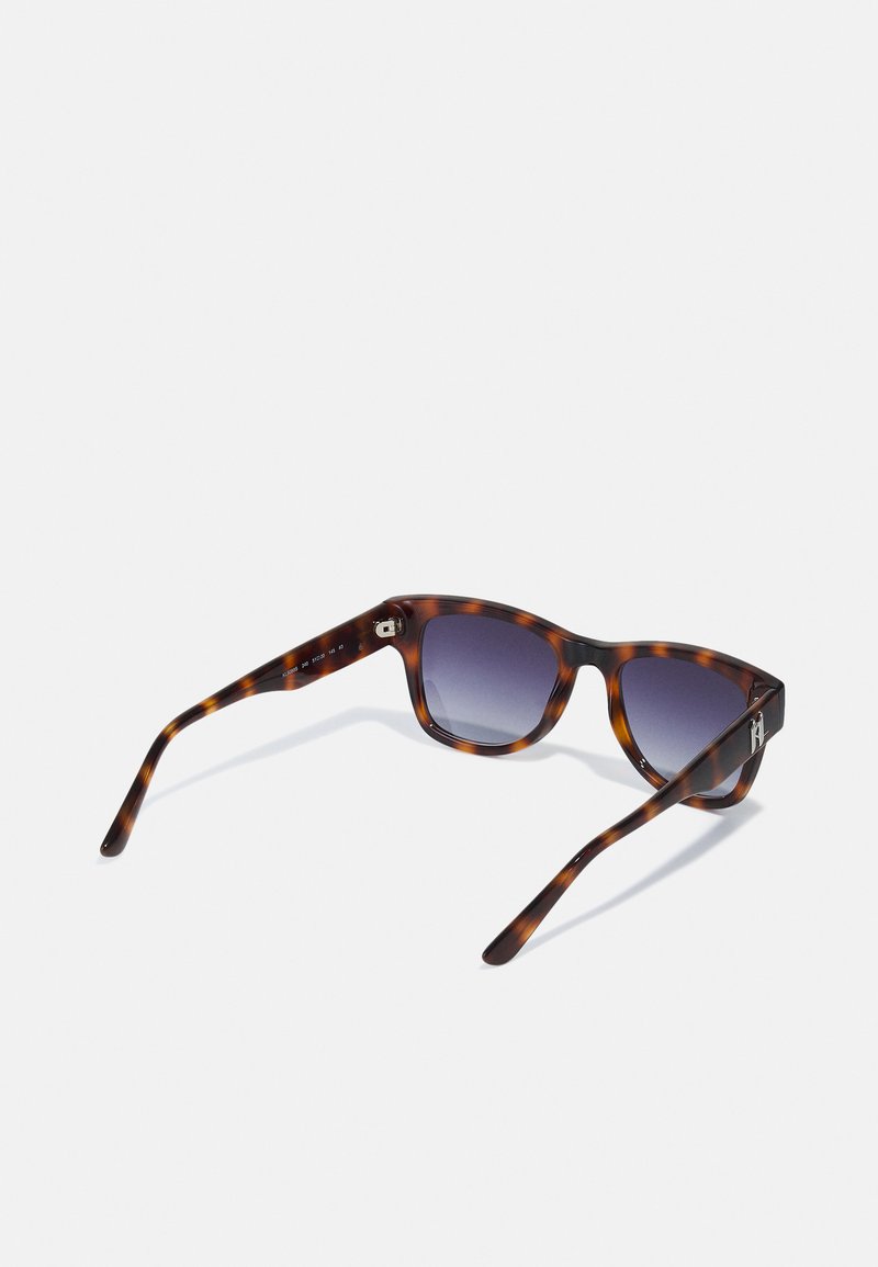 Schildpatt-Sonnenbrille mit lila Farbverlauf-Gläsern, ausgestattet mit einem dicken Rahmen und schlanken Bügeln. Akzentbeschläge an den Schläfen sorgen für Details.