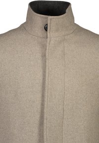 Abrigo de lana beige con un alto cuello, que presenta un cierre de botón negro y una textura suave. Costura detallada a lo largo de la costura frontal.