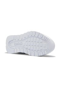 Suela de zapato de goma blanca con superficie texturizada, con una serie de tacos y el logo de Reebok en relieve en el centro. Bordes lisos, diseño resistente.