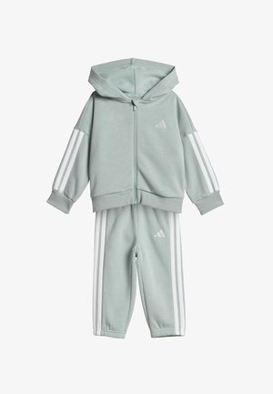 Lichtgroene trainingspakset met een ritshoodie en bijpassende broek. Bevat witte strepen langs de mouwen en zijkanten, gemaakt van zachte stof.