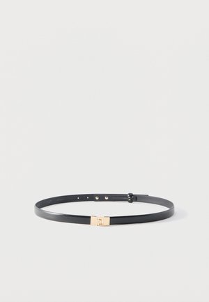 Tenký čierny kožený opasok s malou obdĺžnikovou zlatou prackou, zobrazený na rovnom hladkom svetlosivom pozadí.