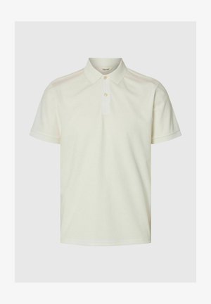 Trumparankovė smėlio spalvos polo marškinėliai su dviem sagutėmis ir klasikiniais apykakle, pateikti ant paprasto šviesaus fono.