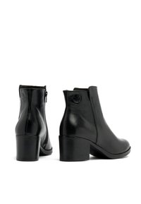 Botas de tobillo de cuero negro con tacón cuadrado, que cuentan con un cierre lateral, textura suave y un sutil detalle de logo cerca del talón.
