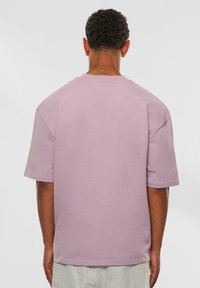 Lyse lilla oversized t-shirt lavet af bomuld, med rund hals, korte ærmer og en glat tekstur med minimal dekoration.