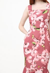 Rotes Blumenkleid mit taillierter Passform, großen Orchideenmustern, quadratischem Ausschnitt und weitem Saum. Glatte Stofftextur.