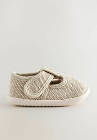 Petite chaussure en tissu tissé beige avec semelle blanche douce et bride à scratch réglable, conçue pour le confort et la facilité d'utilisation.