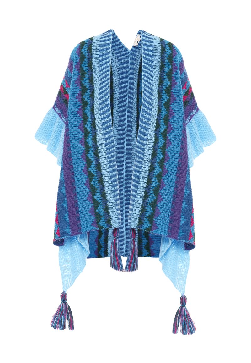 Stickad poncho med en blå färgskala och zigzag-mönster, fransdetaljer och tofsar vid fållen. Mjuk textur och öppen framsida.