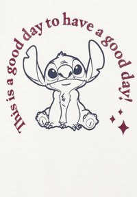 Bílá tkanina s kreslenou postavičkou s velkýma ušima a výrazy očí, obklopená textem v burgundské barvě: "Dnes je dobrý den mít dobrý den!"