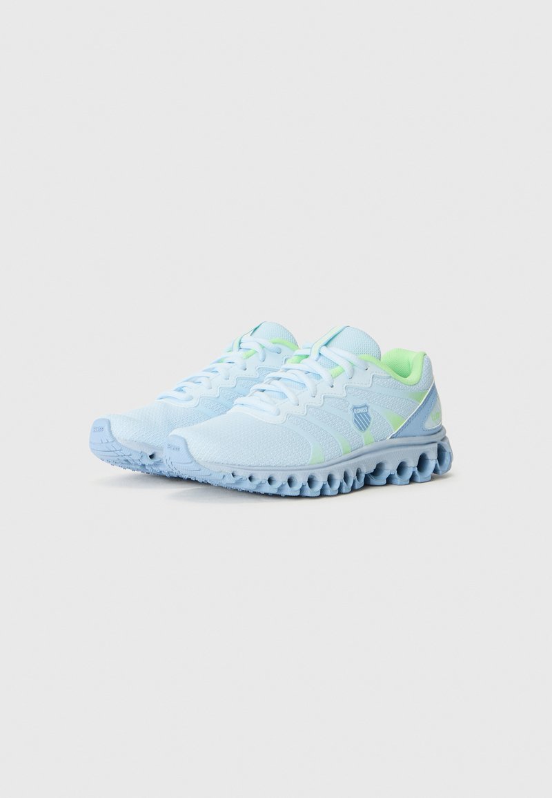 Hellblaue Sportschuhe mit neon-grünen Akzenten und einer gepolsterten Sohle, dargestellt vor einem schlichten weißen Hintergrund.