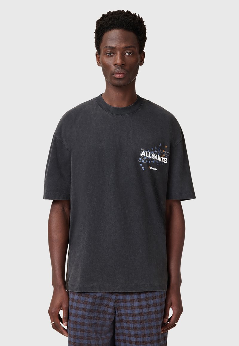 Sort oversized T-shirt med rund hals, med trykt logo og stjernedesign på brystet. Glat bomuldsstof, afslappet pasform.