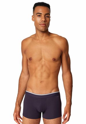 Boxer briefs blu navy con una cintura elastica bianca, realizzati in tessuto morbido, con una vestibilità aderente e una tasca sagomata nella parte anteriore.