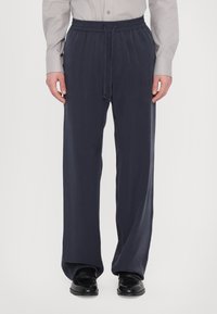 Laivastonsiniset leveät housut pehmeästä kankaasta, joissa on joustava vyötärö nyöreillä ja sivusaumat lisämukavuutta varten.