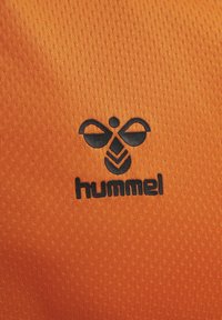 Oranje textiel met een zwarte logo van een abstracte bij ontwerpen met daaronder het woord "hummel".