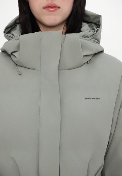 Hele hallhall puffer jope kõrge krae ja kapuutsiga. Omab stiilset disaini, pehmet tekstuuri ja diskreetset brändi logo küljes.