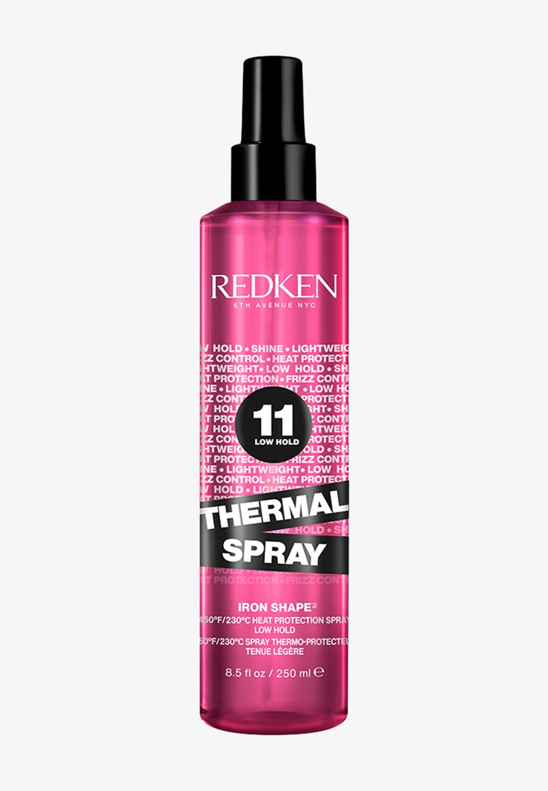 Redken Thermal Spray in een heldere, lange roze fles met een zwarte pomp. Voorzien van witte en zwarte tekst die lage hold en hittebescherming benadrukt.