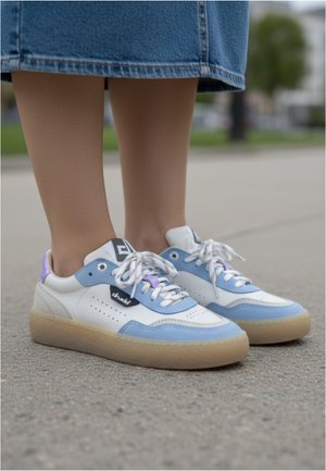 Baskets blanches et bleu clair avec des accents en cuir texturé et en maille. Elles présentent une semelle épaisse crème, des détails lavande et noirs, et des lacets à motifs.