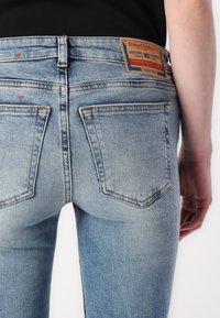 Jeans din denim de culoare albastră deschisă, cu un design ajustat. Prezintă o etichetă din piele a brandului, detalii cusute și două buzunare din spate cu margini curbate.