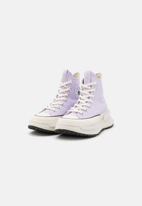 Höga sneakers i ljuslila canvas med vita accenter. Har rund logopatch, krämfärgade snörningar och tjock sula i svart gummi.