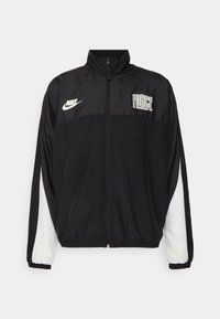 Black and white Nike sports jacket with full front zipper, "FORCE" text on right chest, and elastic cuffs on sleeves.