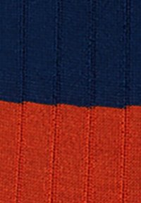 Tessuto di cotone con righe verticali; la parte superiore è di un blu scuro e la parte inferiore è arancione. La consistenza è morbida e a coste.