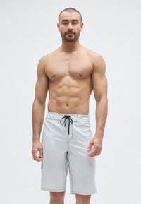 Férfi világosszürke fürdőnadrág, vízlepergető anyagból, derékrészen húzózsinórral, oldalzsebekkel és kontrasztos fekete varrással.