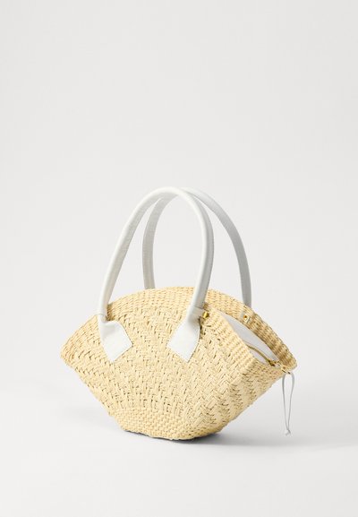 Sac en paille tissée avec des poignées en cuir blanc, de forme arrondie et fermeture éclair. Surface texturée avec une finition naturelle.
