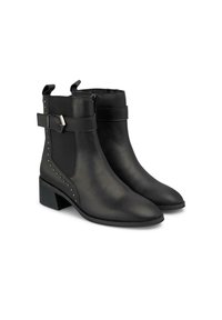 Botines de cuero negro con paneles elásticos en los laterales, punta afilada, tacón cuadrado, acentos de tachuelas a lo largo de los costados y correa ajustable con hebilla.