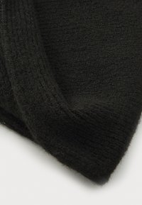 Schwarzer Strickstoff mit weicher Textur, der ein geripptes Muster und einen umgeschlagenen Rand aufweist. Das Material wirkt warm und gemütlich.