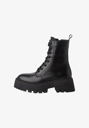 Melna ādas potītes zābaki ar auklām, apaļu purngalu, masīvu platformas zoli un vilkšanas cilpu aizmugurē vieglai uzvilkšanai.